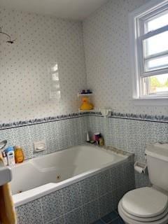 48-13 216th St, Bayside, NY 11364 - bathroom with tiled tub, healthy amount of natural light, toilet, and tile patterned floors