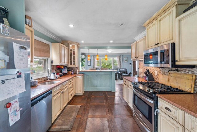 773 Mile Square Rd, Yonkers, NY 10704 - kitchen with cream cabinetry, appliances with stainless steel finishes, a sink, a peninsula, and tasteful backsplash