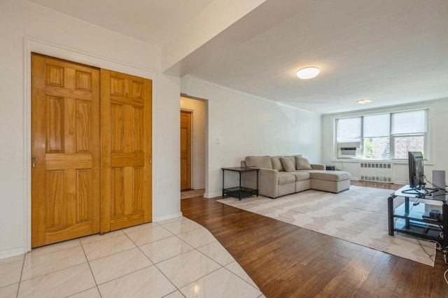 18-50 211th St Unit 2D, Bayside, NY 11360 - living area with radiator, baseboards, light wood-style floors, and cooling unit