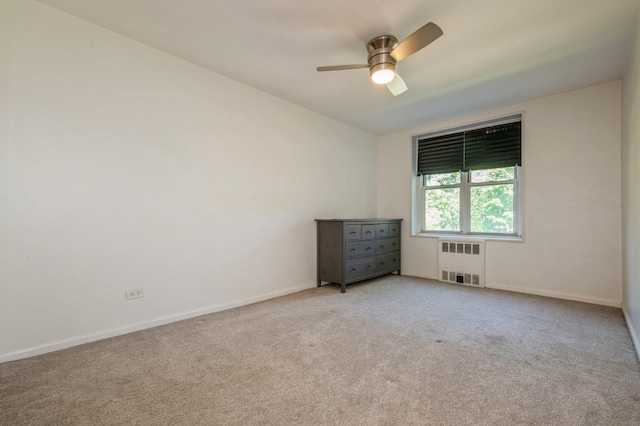 18-50 211th St Unit 2D, Bayside, NY 11360 - spare room with radiator heating unit, a ceiling fan, light carpet, and baseboards