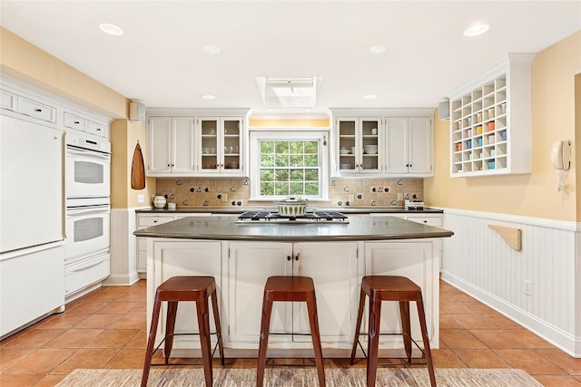 910 New Suffolk Ave, Mattituck, NY 11952 - kitchen featuring refrigerator, stainless steel gas stovetop, a center island, white double oven, and a warming drawer