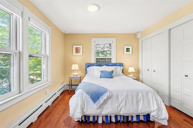 910 New Suffolk Ave, Mattituck, NY 11952 - bedroom featuring baseboard heating, multiple windows, and wood finished floors
