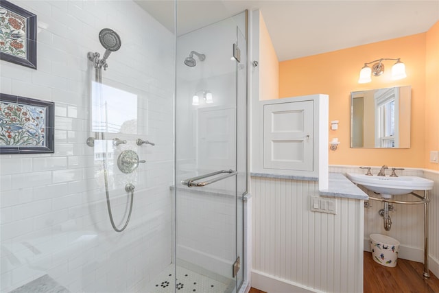 910 New Suffolk Ave, Mattituck, NY 11952 - full bathroom featuring a stall shower, a sink, wood finished floors, and a wainscoted wall