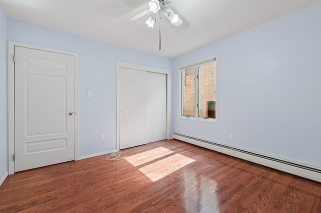 200-15 16th Ave, Bayside, NY 11360 - unfurnished bedroom featuring baseboard heating, wood finished floors, a closet, baseboards, and a ceiling fan