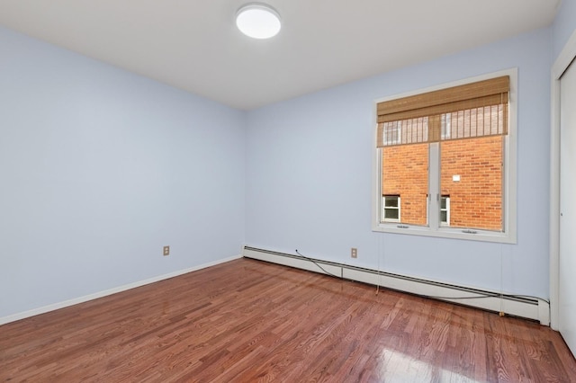 200-15 16th Ave, Bayside, NY 11360 - empty room with wood finished floors, baseboard heating, and baseboards