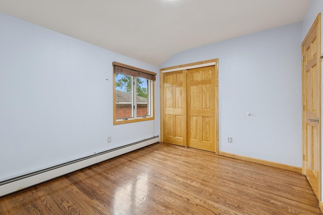 200-15 16th Ave, Bayside, NY 11360 - unfurnished bedroom featuring baseboard heating, light wood-type flooring, vaulted ceiling, a closet, and baseboards