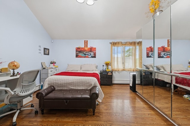200-15 16th Ave, Bayside, NY 11360 - bedroom with vaulted ceiling, baseboard heating, and wood finished floors