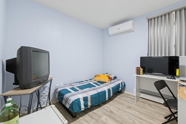 200-15 16th Ave, Bayside, NY 11360 - bedroom featuring a wall unit AC, light wood-style flooring, baseboards, and baseboard heating