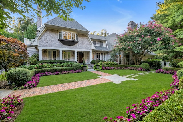4 Pond Ln, Sands Point, NY 11050 - view of front of property featuring french doors, a front lawn, and a chimney