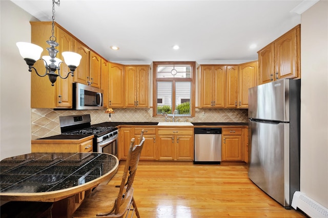 26 Adams Ave, Bayville, NY 11709 - kitchen with appliances with stainless steel finishes, a sink, a chandelier, light wood-style floors, and tile counters