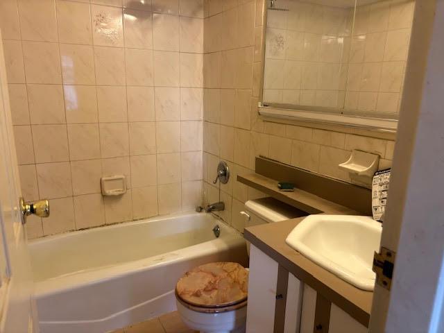 353 Ocean Ave Unit 4G, Brooklyn, NY 11226 - full bathroom featuring toilet, shower / bath combination, vanity, and tile walls