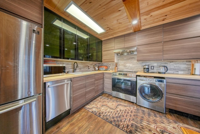 6 Medallion Rd, Kiamesha Lake, NY 12751 - kitchen with washer / dryer, stainless steel appliances, a sink, decorative backsplash, and under cabinet range hood