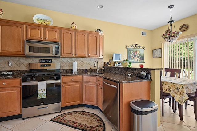 5 Mantack Path, Kings Park, NY 11754 - kitchen featuring appliances with stainless steel finishes, a sink, a peninsula, light tile patterned floors, and dark stone countertops