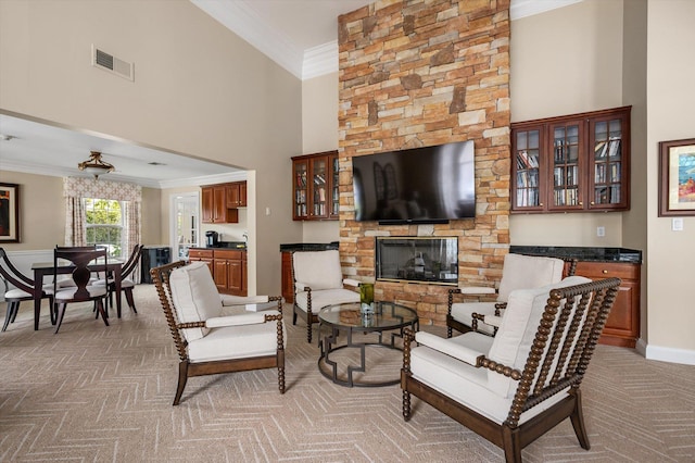 5 Mantack Path, Kings Park, NY 11754 - living room featuring light carpet, ornamental molding, a towering ceiling, baseboards, and a stone fireplace