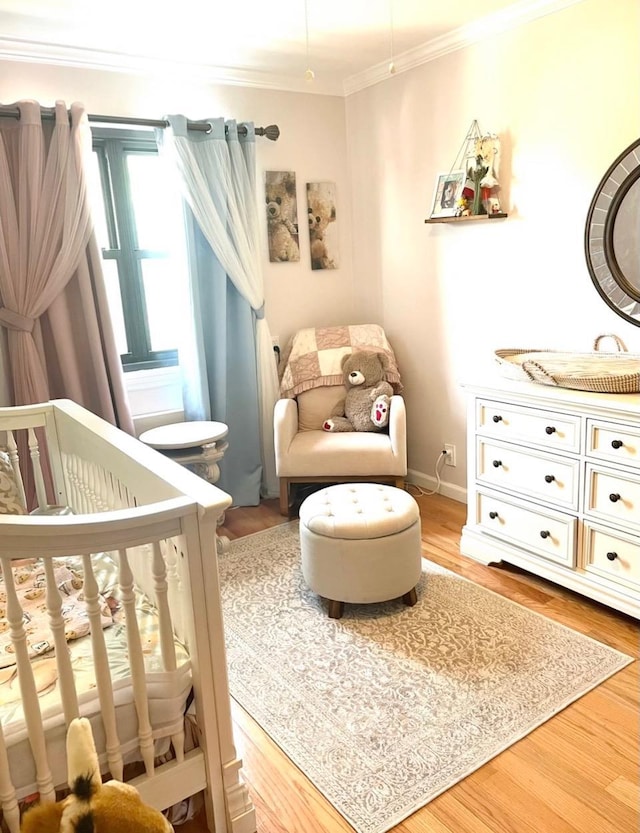 57-21 246th Cres Unit 1Fl, Douglaston, NY 11362 - bedroom featuring a nursery area, crown molding, and wood finished floors