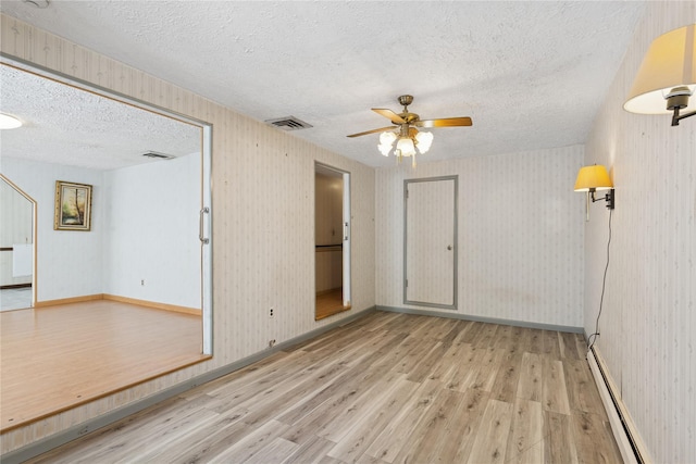 26 Beach Ave, Port Jefferson Station, NY 11776 - spare room featuring a textured ceiling, wood finished floors, baseboard heating, ceiling fan, and baseboards