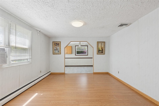 26 Beach Ave, Port Jefferson Station, NY 11776 - empty room with a baseboard radiator, wood finished floors, and a textured ceiling