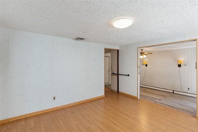 26 Beach Ave, Port Jefferson Station, NY 11776 - unfurnished room with wood finished floors, a textured ceiling, a baseboard radiator, ceiling fan, and baseboards