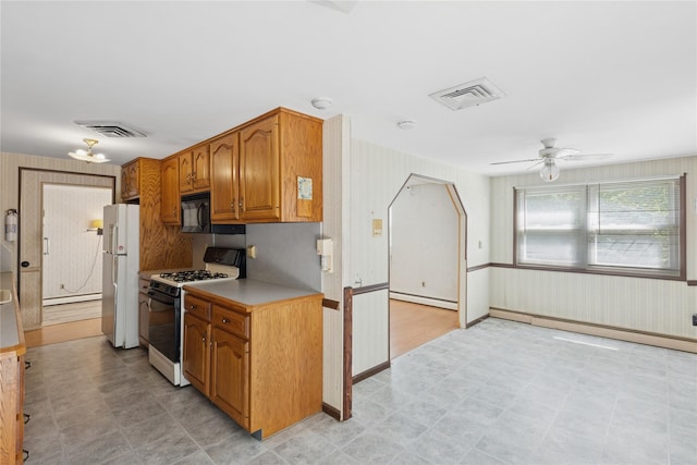26 Beach Ave, Port Jefferson Station, NY 11776 - kitchen featuring range with gas stovetop, freestanding refrigerator, a baseboard heating unit, black microwave, and a ceiling fan
