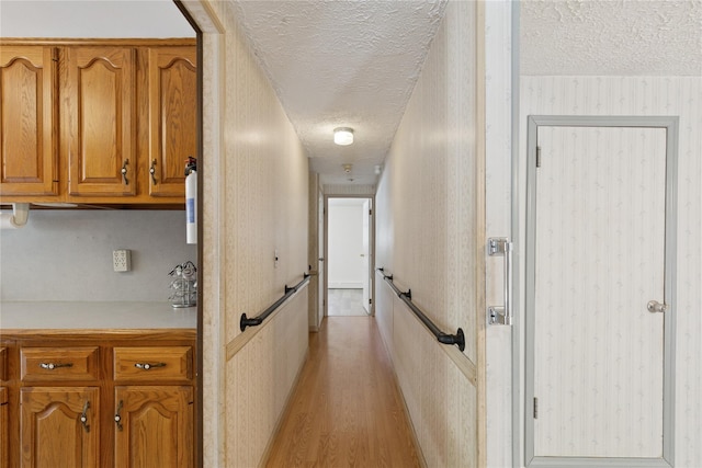 26 Beach Ave, Port Jefferson Station, NY 11776 - hallway featuring a textured ceiling, light wood-type flooring, and wallpapered walls