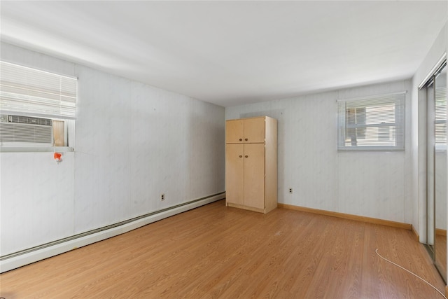 26 Beach Ave, Port Jefferson Station, NY 11776 - empty room featuring a baseboard heating unit, light wood-style flooring, and cooling unit