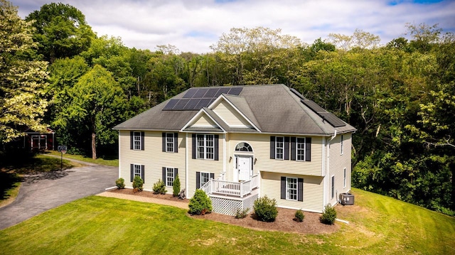 5692 Rte 82, Clinton Corners, NY 12514 - split foyer home featuring solar panels, a front lawn, central AC unit, asphalt driveway, and a wooded view
