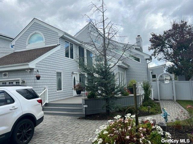 738 Shore Walk, Lindenhurst, NY 11757 - view of home's exterior with a chimney and a gate
