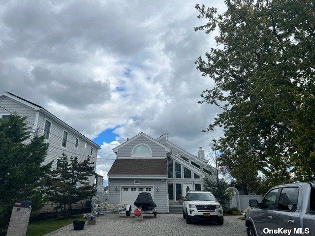 738 Shore Walk, Lindenhurst, NY 11757 - view of front facade featuring a chimney and driveway