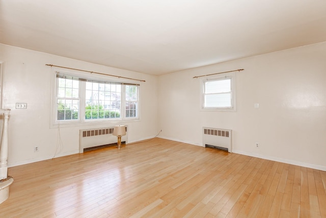 30 Jean Dr, North Babylon, NY 11703 - empty room with radiator, light wood finished floors, and plenty of natural light