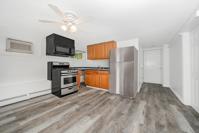 15 W Granada Ave, Lindenhurst, NY 11757 - kitchen with appliances with stainless steel finishes, a wall mounted AC, light wood-type flooring, brown cabinetry, and ceiling fan