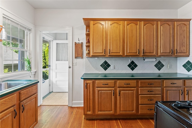 27 Luzern Rd, Dobbs Ferry, NY 10522 - kitchen with light wood-style floors, brown cabinets, decorative backsplash, and electric range