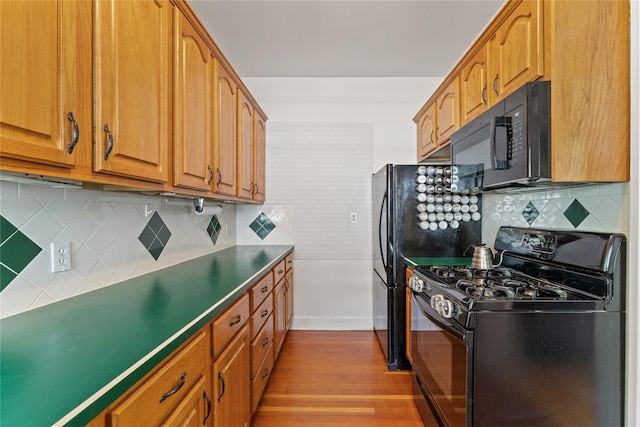 27 Luzern Rd, Dobbs Ferry, NY 10522 - kitchen with black appliances, decorative backsplash, wood finished floors, and brown cabinets