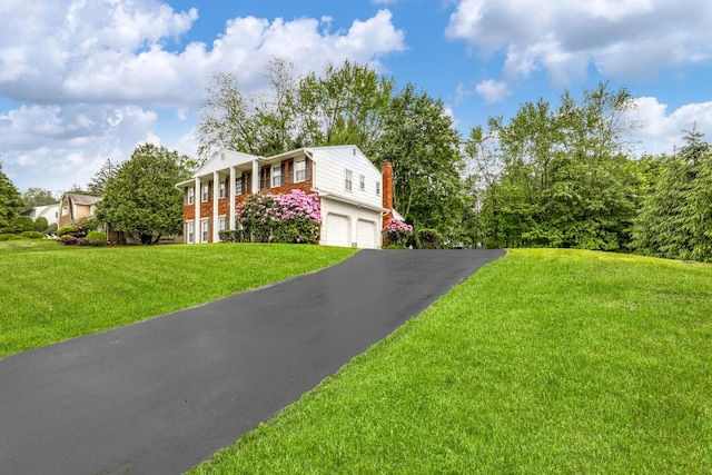 1 Lodi Ln, Monsey, NY 10952 - neoclassical / greek revival house with a chimney, driveway, an attached garage, a front lawn, and brick siding
