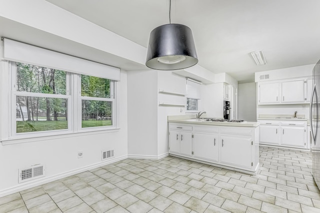 1 Lodi Ln, Monsey, NY 10952 - kitchen featuring white cabinets, light countertops, a peninsula, white gas stovetop, and baseboards