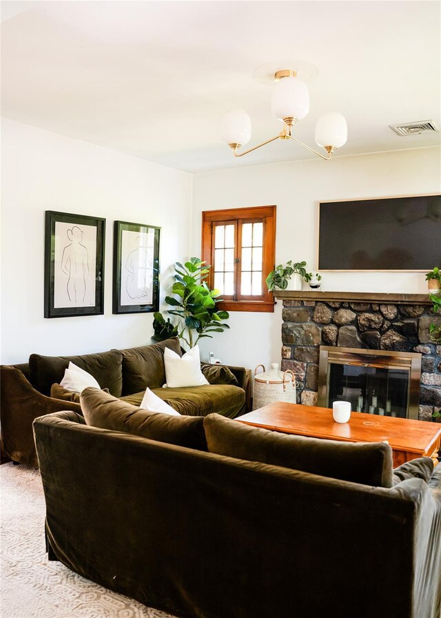 222 Lakeside Rd, Newburgh, NY 12550 - living room with a stone fireplace, carpet floors, and a chandelier
