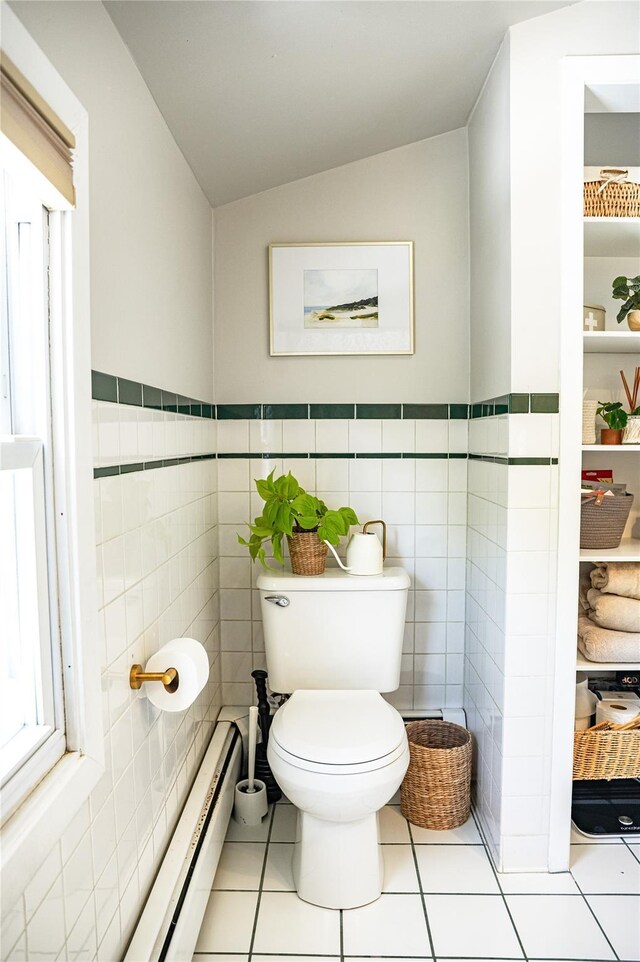 222 Lakeside Rd, Newburgh, NY 12550 - bathroom with toilet, vaulted ceiling, tile walls, wainscoting, and tile patterned flooring