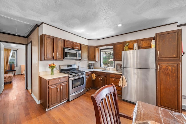 7 Crestwood Trl, Monroe, NY 10950 - kitchen featuring stainless steel appliances, light countertops, ornamental molding, light wood-style flooring, and brown cabinets