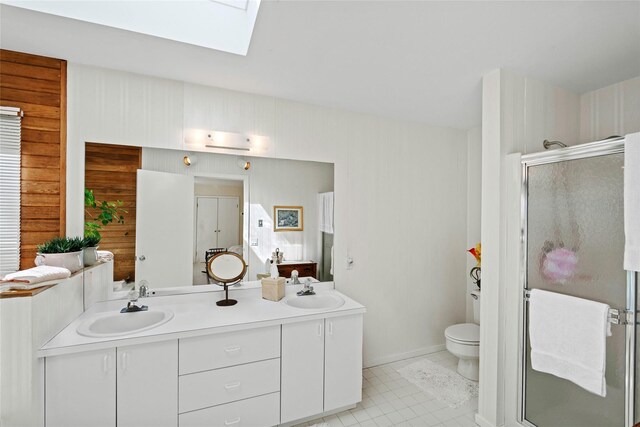 15 Elizabeth Ln, Quogue, NY 11959 - bathroom featuring double vanity, a skylight, a shower stall, toilet, and baseboards