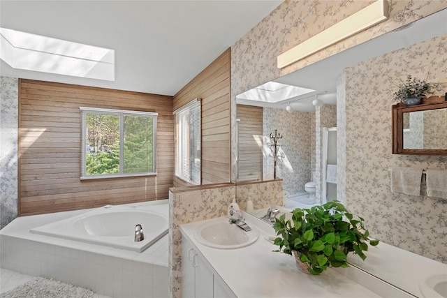 15 Elizabeth Ln, Quogue, NY 11959 - full bath with a skylight, wallpapered walls, a garden tub, vanity, and toilet