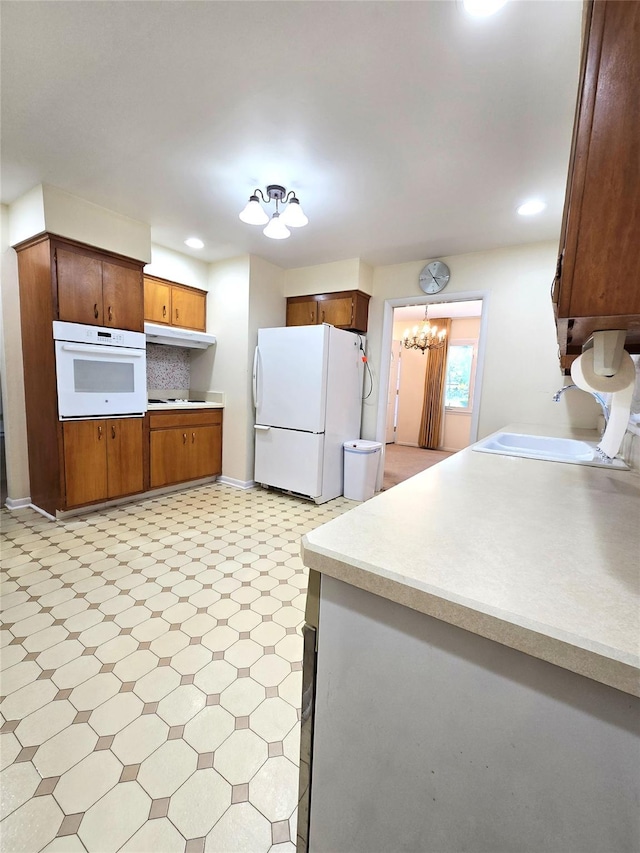 31 Whittier Blvd, Poughkeepsie, NY 12603 - kitchen featuring white appliances, a sink, light floors, light countertops, and a chandelier