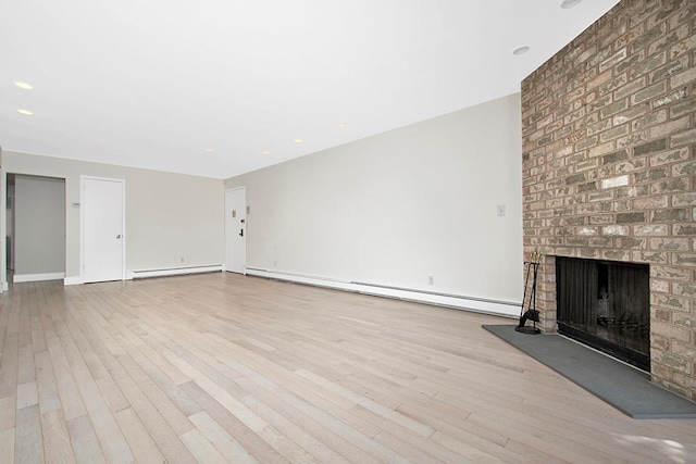 107 N Broadway Unit 201, White Plains, NY 10603 - unfurnished living room featuring a baseboard heating unit, wood finished floors, and a brick fireplace