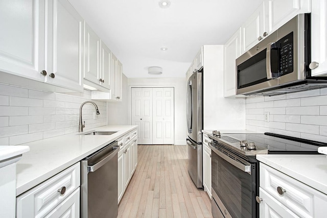 107 N Broadway Unit 201, White Plains, NY 10603 - kitchen featuring appliances with stainless steel finishes, a sink, tasteful backsplash, white cabinets, and recessed lighting