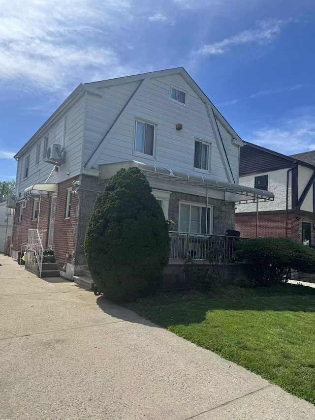 58-16 185th St, Fresh Meadows, NY 11365 - view of front of property with a front yard, central AC, a gambrel roof, brick siding, and stone siding