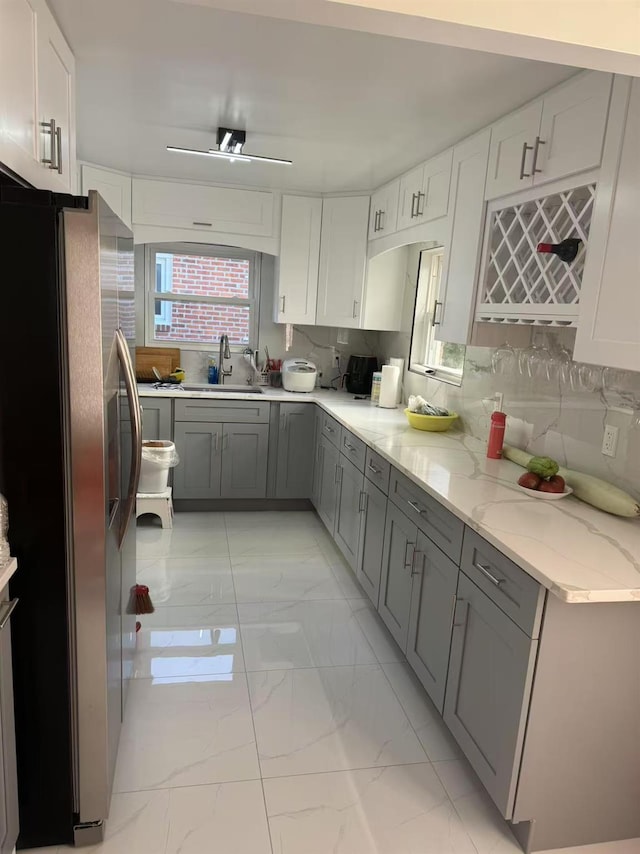 58-16 185th St, Fresh Meadows, NY 11365 - kitchen with freestanding refrigerator, light marble finish floors, a sink, gray cabinets, and light stone countertops