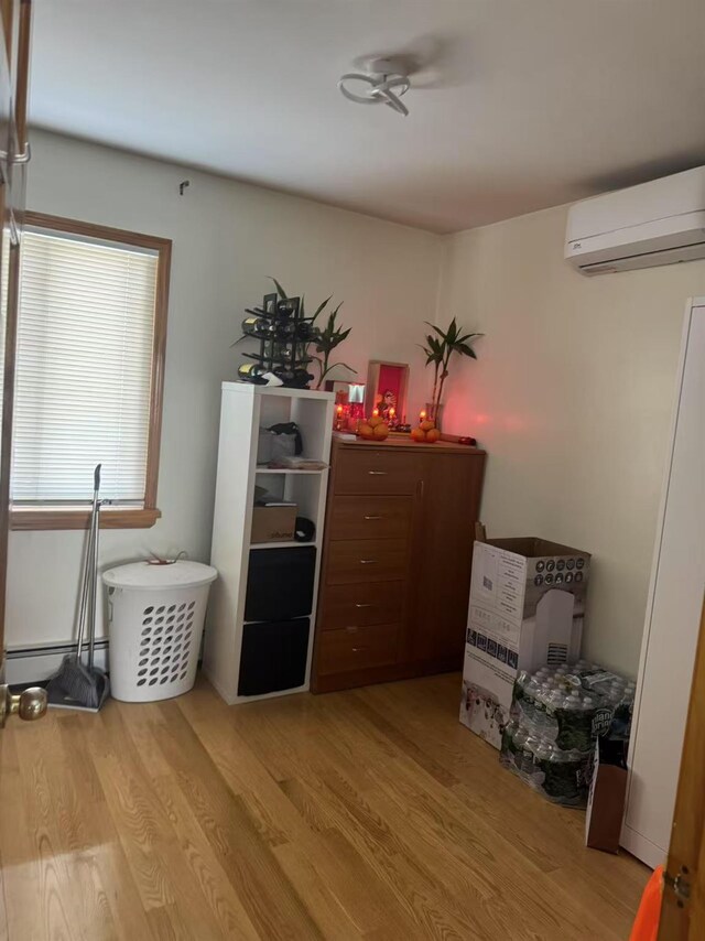 58-16 185th St, Fresh Meadows, NY 11365 - bedroom with a wall mounted AC, light wood-style floors, and baseboard heating