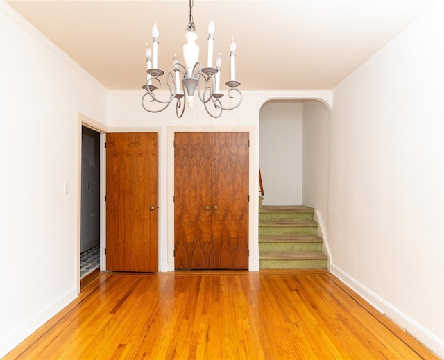 28-06 34th Ave, Astoria, NY 11106 - unfurnished dining area with a chandelier, light wood-type flooring, stairs, crown molding, and baseboards