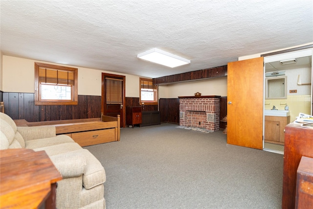 28-06 34th Ave, Astoria, NY 11106 - carpeted living room with a wainscoted wall, wooden walls, a textured ceiling, and a brick fireplace