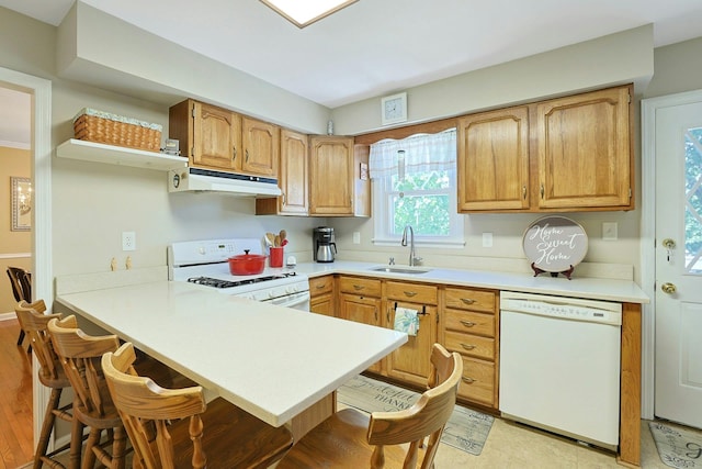 53 Prior Pl, Yonkers, NY 10710 - kitchen with white appliances, under cabinet range hood, a sink, a peninsula, and a kitchen breakfast bar