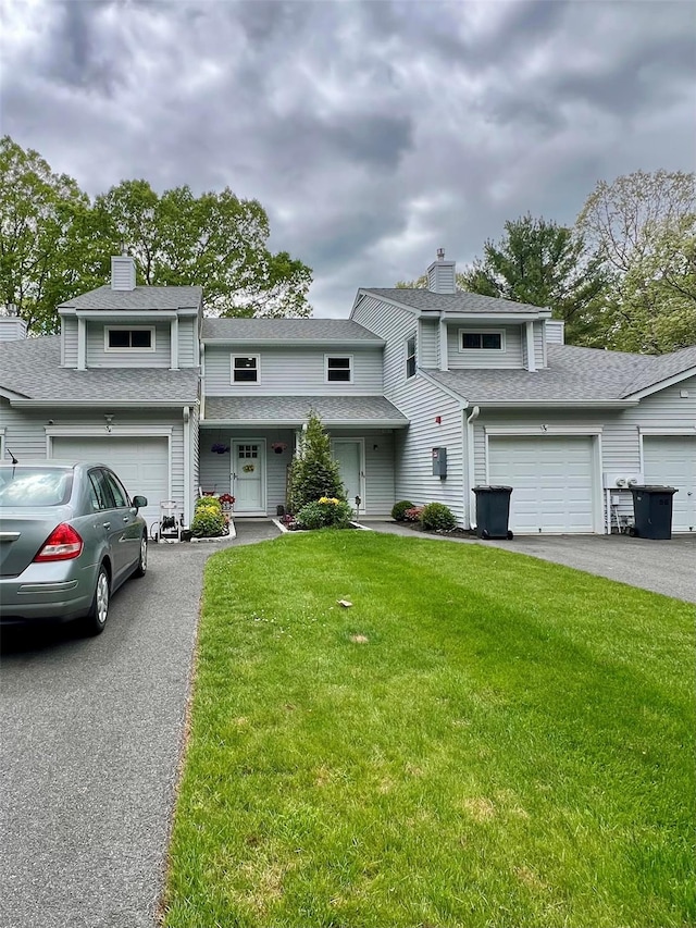 54 Cobbleridge, Manorville, NY 11949 - view of property featuring a front lawn, asphalt driveway, a chimney, and a garage