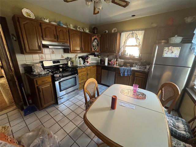5307 65th Pl, Maspeth, NY 11378 - kitchen with appliances with stainless steel finishes, under cabinet range hood, backsplash, and dark countertops